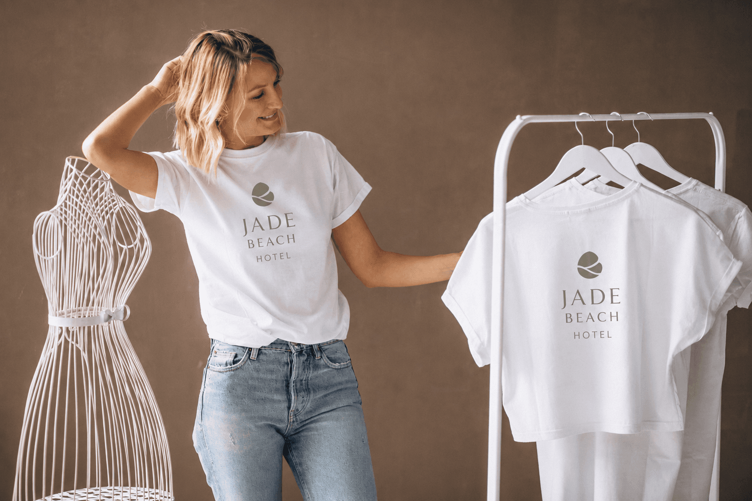 Woman modelling a Jade Beach Hotel branded t-shirt next to a rack of hotel merchandise